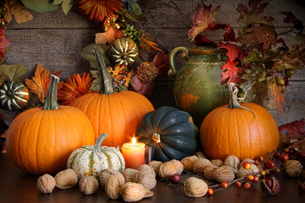 Decorative gourds, leaves, berries, and a candle